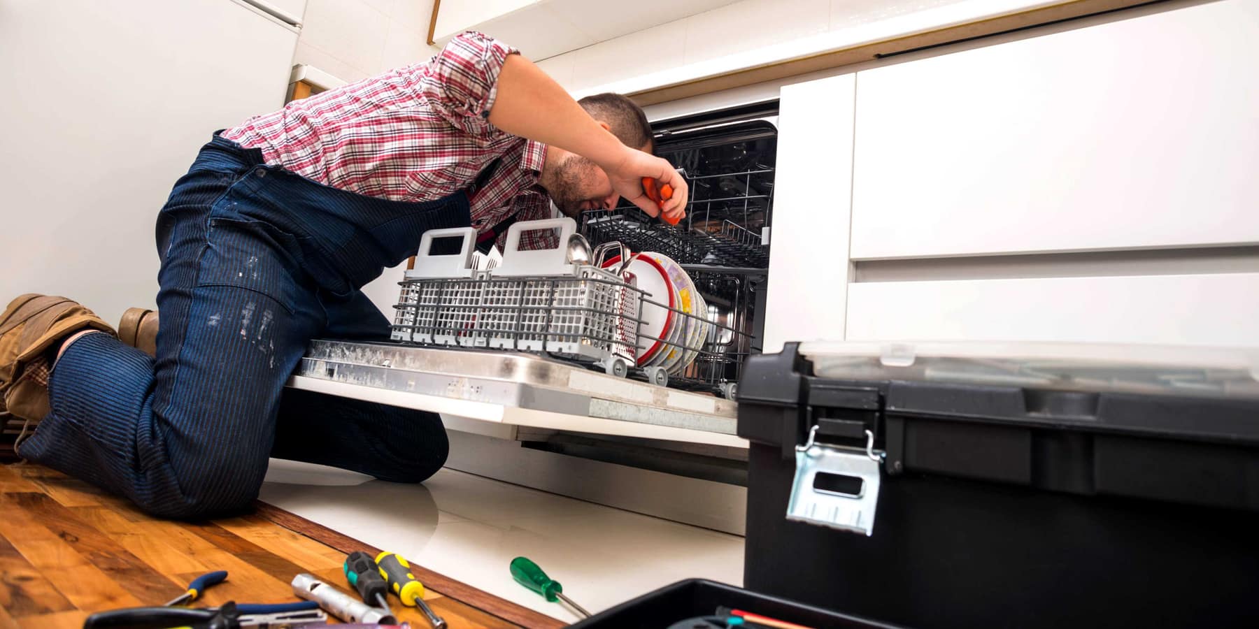 Our engineer repairing a dishwasher in a customer's kitchen